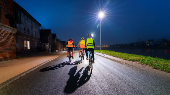 mensen aan het fietsen in een verlichte straat 